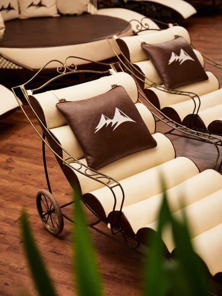 Bildergalerie Elegante Spa-Liegestühle mit braunen Kissen mit Berglogo auf Holzfußboden